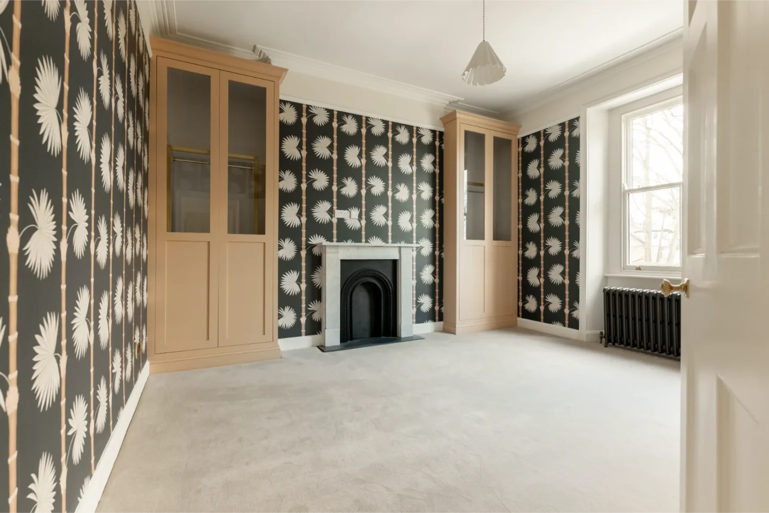 Empty room with patterned walls and fireplace.