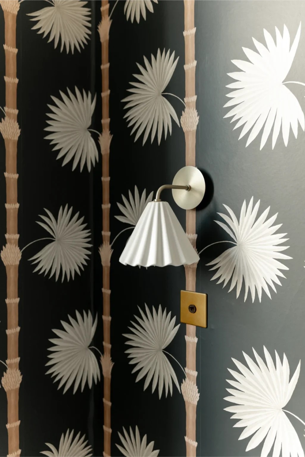 Palm leaf wallpaper with wall sconce