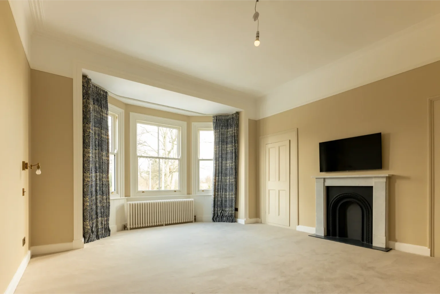 Empty room with fireplace and bay windows.