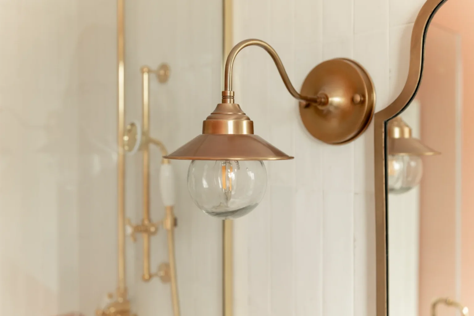 Elegant brass sconce beside a mirror.