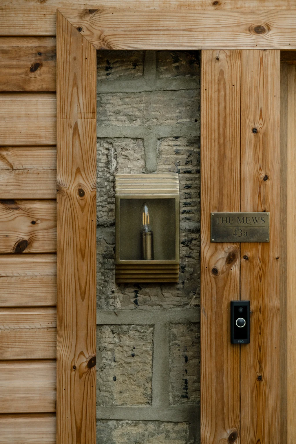 Wooden door with wall light and doorbell