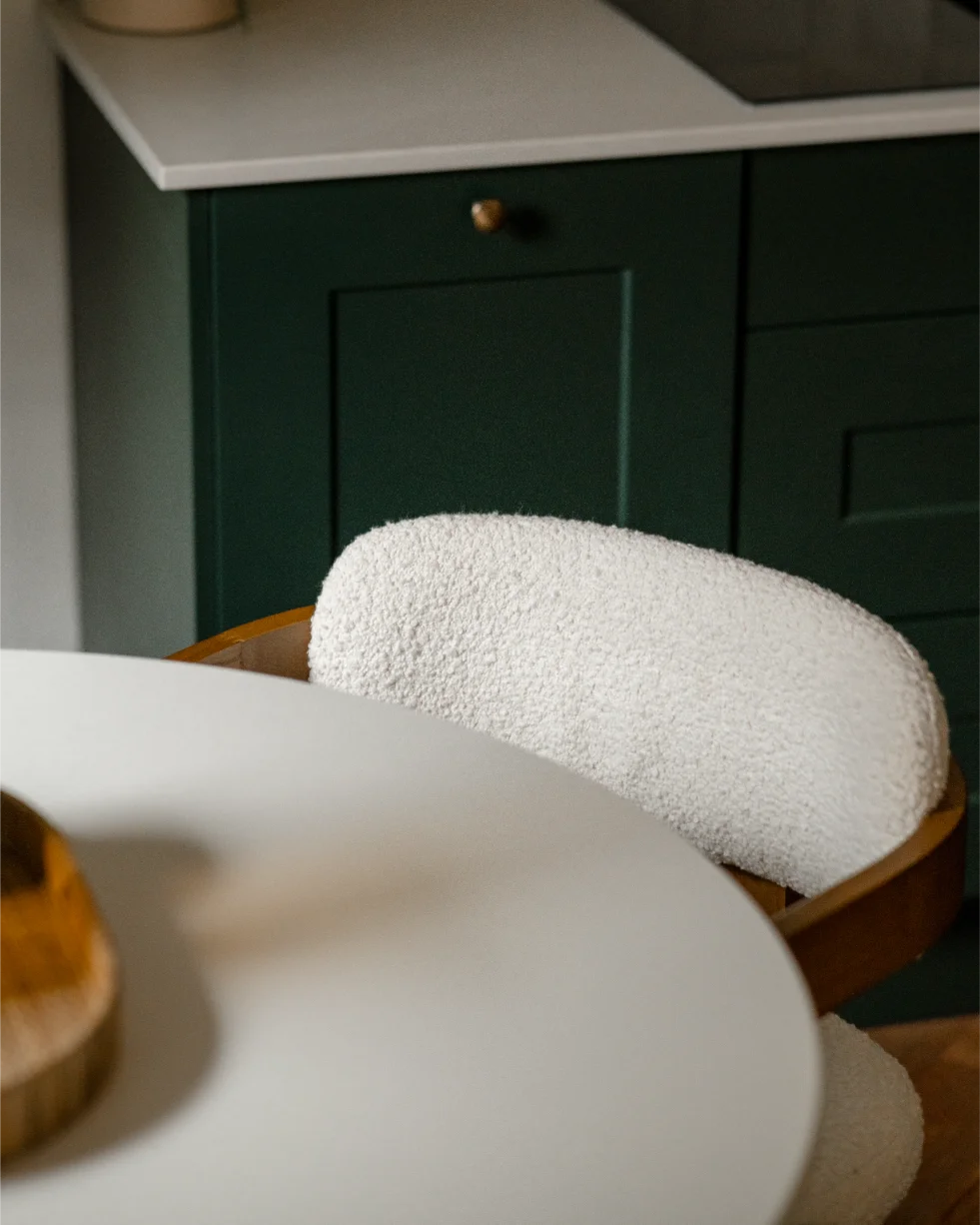 White round table and green kitchen cabinets