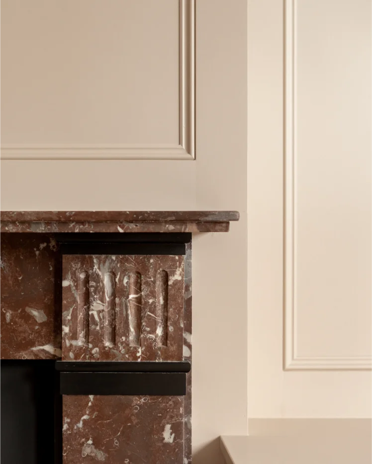 Elegant marble fireplace with beige paneled wall