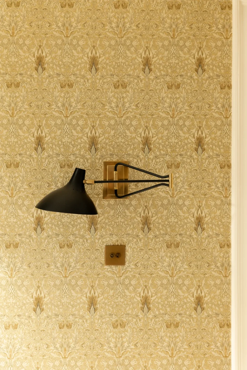 Wall lamp on floral patterned wallpaper