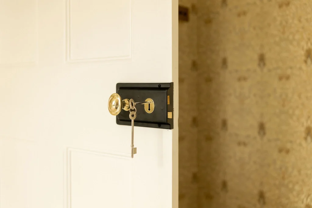 Old-fashioned key in white door lock.