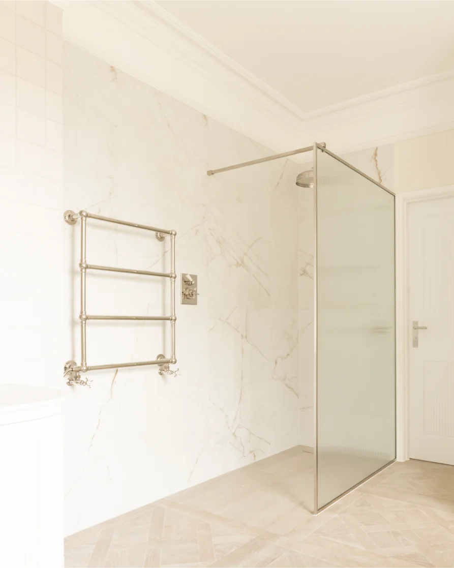 Minimalist bathroom with glass shower and towel rack.