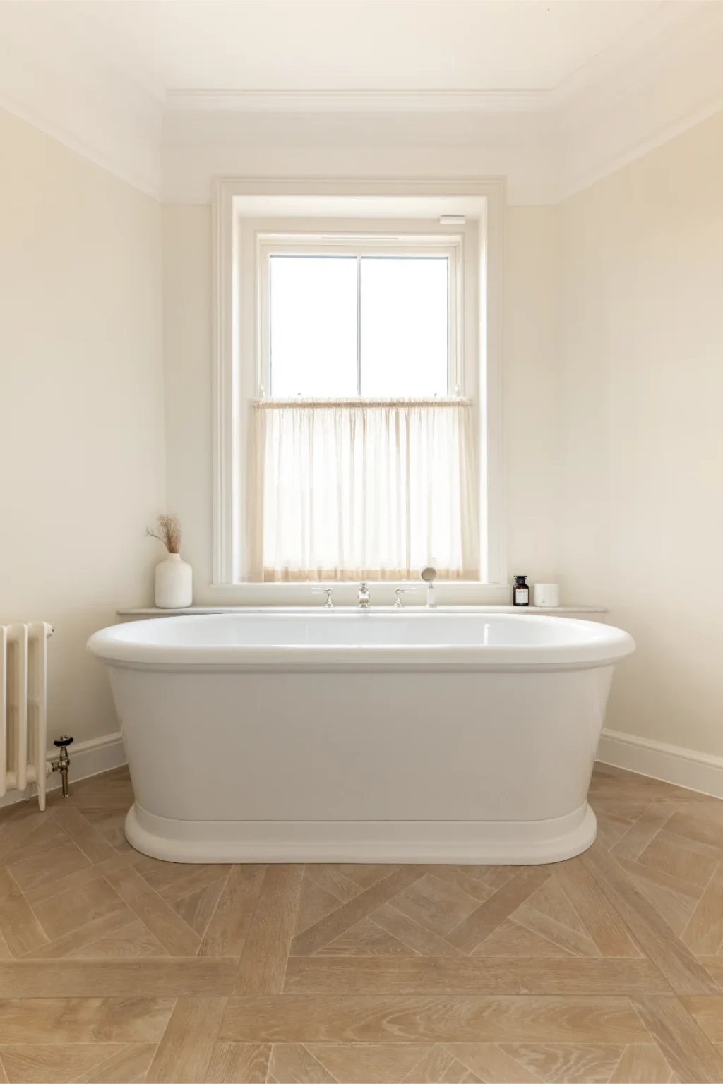 Elegant bathroom with freestanding tub and wood floor.
