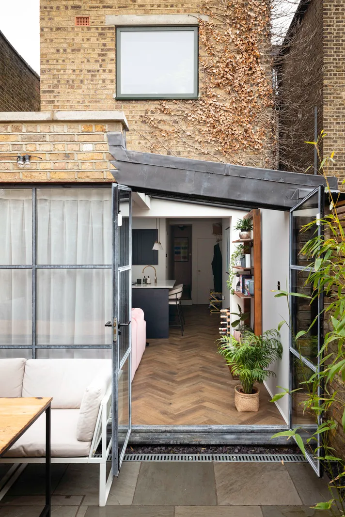 Modern home extension with open doors and plants.