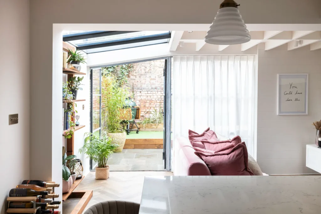 Modern living room with garden view and pink couch.